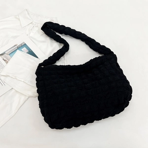 Macro detail of black bubble textured fabric and zipper closure on cloud shoulder bag