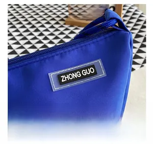 Detail of royal blue nylon bag showing the zip closure and 'ZHONG GUO' rubber patch