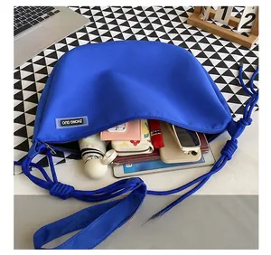 Top view of large capacity nylon crossbody bag showing spacious interior with daily essentials