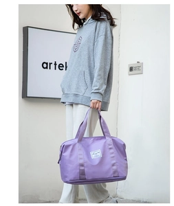 Detalle de la bolsa de viaje de nailon violeta impermeable con logo y asas tejidas