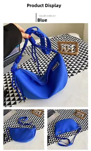 Detail of blue nylon crescent bag with braided knot shoulder strap and label