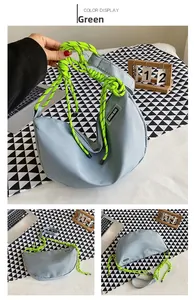 Detail of light blue nylon crescent bag with bright fluorescent green rope handle