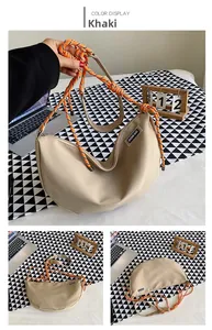 Detail of khaki nylon half-moon crossbody bag with bold orange woven rope strap