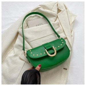 Détail du sac en cuir vert avec rivets dorés et grande boucle métallique en forme de U