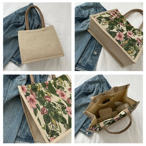 Detail view showing tropical hibiscus print on a large canvas tote with brown handles