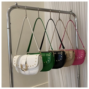 Détail de cinq sacs bandoulière cloutés en blanc, vert, noir, kaki et rose vif de mode