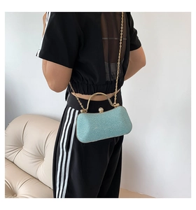 Detail of light blue sequined evening clutch with gold handle and sparkling clasp