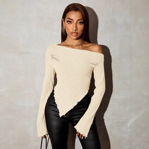Detail showing the off-shoulder neckline and asymmetric V-hem design of the cream knit top