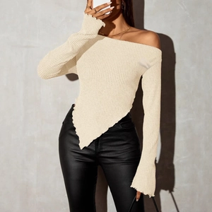 Close-up of cream off-shoulder knit top with asymmetrical hem and ribbed texture