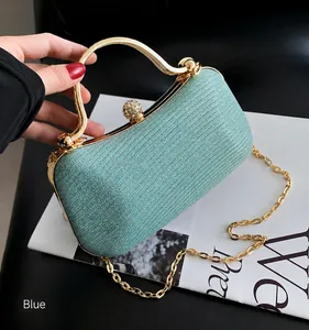 Detail of blue sequin evening bag featuring gold handle, chain strap, and diamond clasp