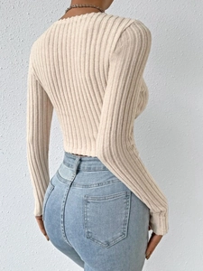 Rear view of beige ribbed long sleeve knit top paired with high waist blue jeans