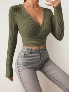 Detail of olive green ribbed knit top featuring a deep V-neck and wrap design