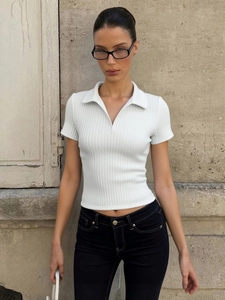 Detail of white ribbed knit polo shirt featuring a V-neckline and slim fit design