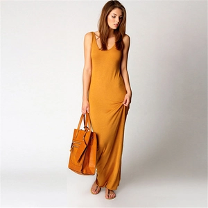 Close-up of a mustard yellow sleeveless maxi dress with a brown leather tote bag