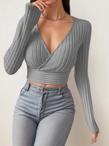 Detail of grey ribbed knit long sleeve crop top with cross deep V-neck and slim fit cut