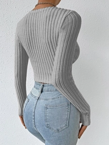 Detail of grey ribbed knit long sleeve top with ruffle hem and slim fit side view