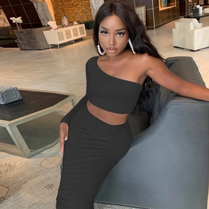 Detail of black two-piece set featuring one-shoulder crop top and side ruched maxi skirt