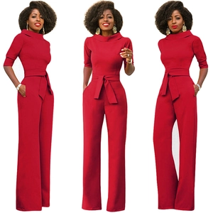 Dettagli di una tuta rossa con collo alto, maniche a metà e cintura annodata in vita