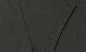 Close-up of premium double-needle stitching on high-quality black knitted fabric