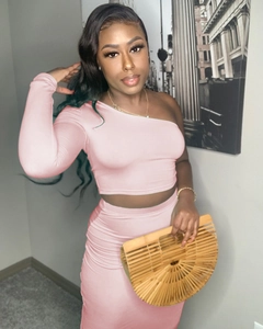 Detail of pink two-piece set featuring a one-shoulder crop top and high-waisted maxi skirt