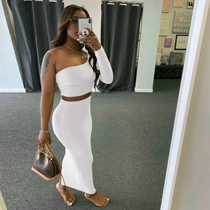 Detail of white one-shoulder long sleeve crop top and high waist maxi skirt set