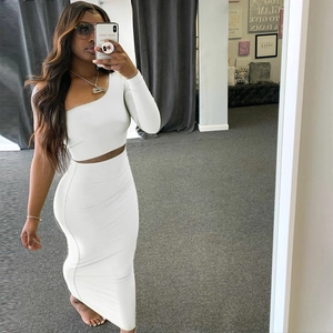 Detail of white two-piece set featuring one-shoulder long sleeve top and high waist maxi skirt