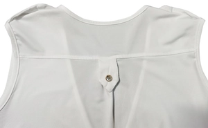 Détail d'une combinaison blanche sans manches avec plis en V et bouton en cristal doré