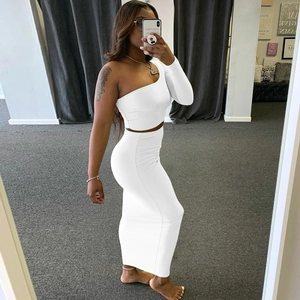Detail of white two-piece set with one-shoulder crop top and high waist maxi skirt