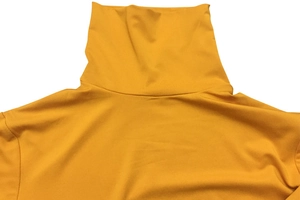 Détail du col montant et texture du tissu sur un body jaune à manches longues