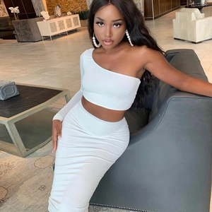 Elegant white two-piece knit set featuring a one-shoulder crop top and a ruched midi skirt