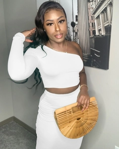 Close-up of elegant white one-shoulder long sleeve crop top and high waist maxi skirt