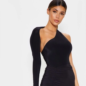 Détail d'un bodysuit asymétrique noir à manche longue avec une jupe plissée chic