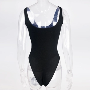Detail view of the black ribbed knit bodysuit with high-cut design on transparent mannequin