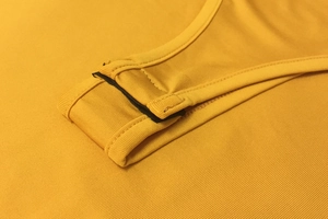 Détails des boutons-pression sur un bodysuit jaune gingembre côtelé avec coutures renforcées