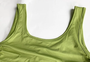 Detail des grünen Strickkleids mit gerippter Textur und feiner Naht am Ausschnitt