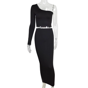 Detail of black two-piece set featuring one-shoulder long sleeve top and high waist maxi skirt