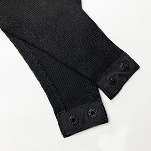 Close-up of black ribbed knit bodysuit featuring functional double snap button closure