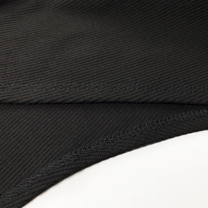 Detailed close-up of black ribbed fabric showing double-stitched seams and texture