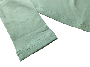 Detailed view of double-stitched hem and cuff on mint green knit two-piece outfit