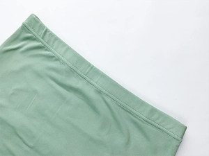 Detailed close-up of double-needle stitching and knit texture on lime green two-piece set