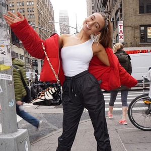 Body sexy blanc à une épaule pour femme avec doudoune rouge dans une rue de ville