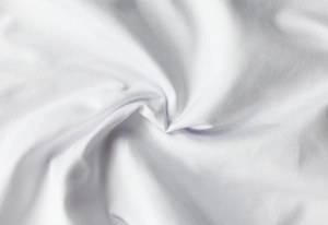 Close-up of premium white knit fabric with elegant draping for slim fit summer dresses