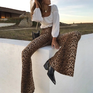 Detail of high waisted leopard print flare pants styled with black pointed boots and top