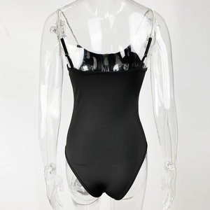 Detail of back view showing diamond-embellished chain strap on black fitted bodysuit