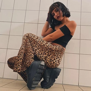 Detail shot of leopard print flared trousers with a high waist and retro animal pattern