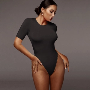Detail of black short sleeve bodysuit showing high-stretch fabric and slim fit on model