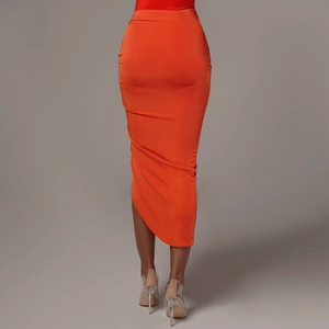 Détail de la jupe midi orange vif avec cordon de serrage latéral et ourlet asymétrique