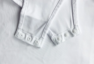 Close-up of white bodysuit bottom with high-quality stitching and three-button snap closure