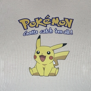 Détail des graphismes Pikachu et du texte sur un débardeur court en maille beige