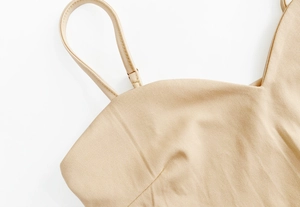 Detailed view of beige backless bodysuit with fine straps and sweetheart neckline